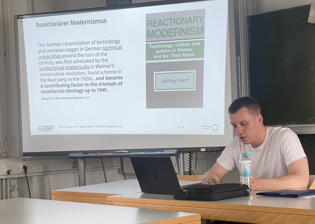 Das Foto zeigt Manuel Clancett bei seinem Vortrag im Rahmen des Forschungskolloquiums am Geschichte Department.
