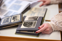 Foto: Alte Fotoalben mit Schwar-weiß-Fotografien liegen auf einem Tisch aus